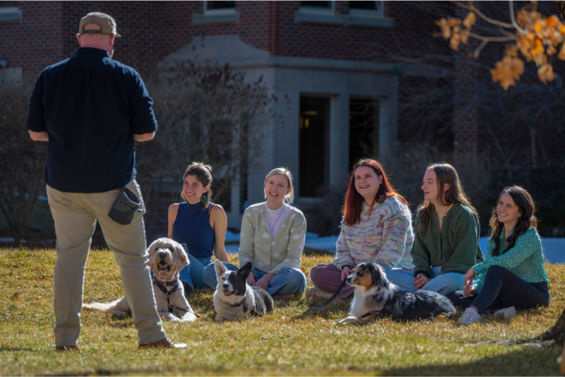 man teaching students with dogs