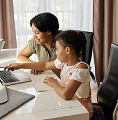child and mother by a laptop