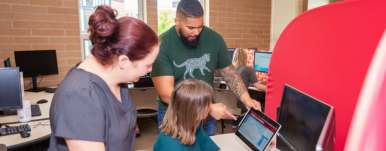 man and woman showing another woman computer data