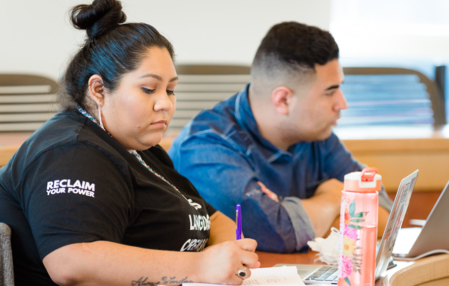 MSW student in class writing in notebook