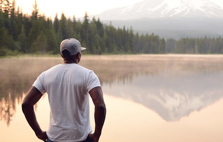 man standing in front of a mountain landscape