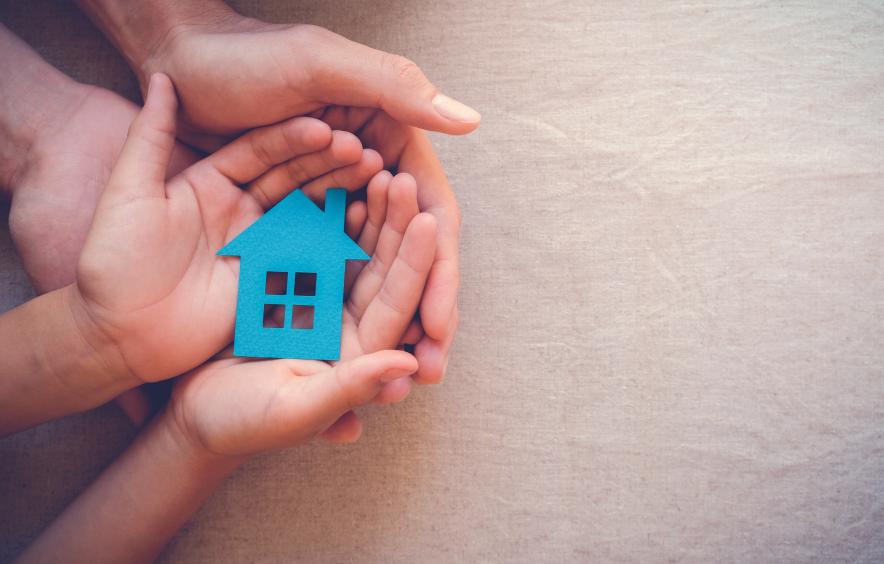 hands holding a paper house