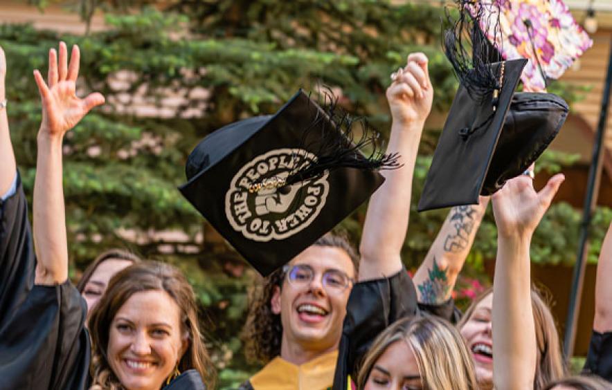 students throwing their caps up in the air