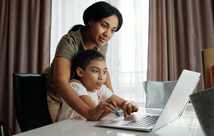 two people in front of a laptop