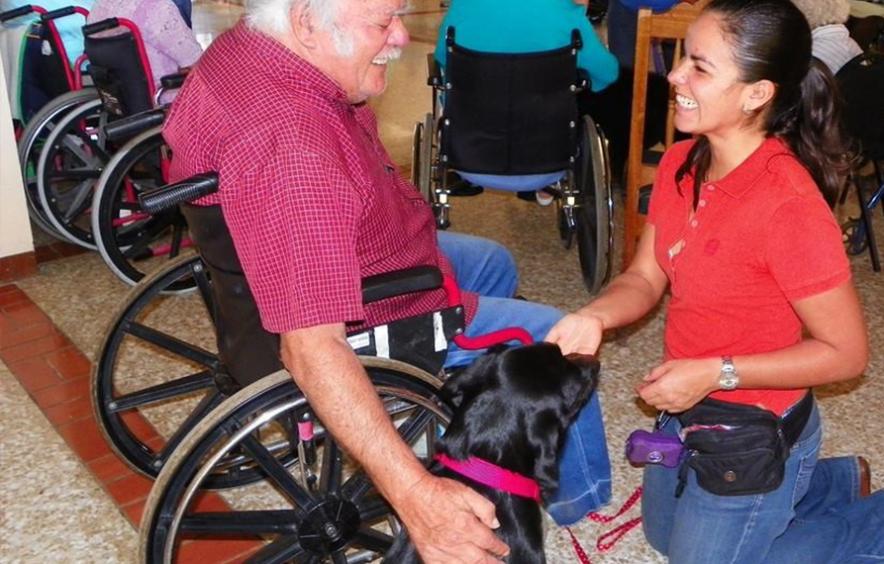 Woman with therapy dog and man in wheelchair