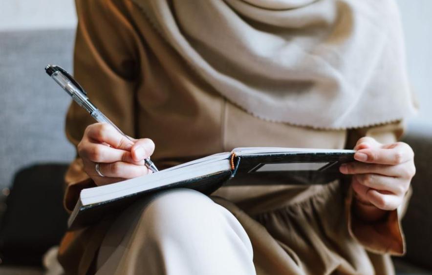 person writing in notebook
