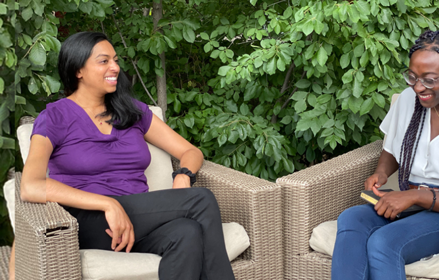Two woman smiling and talking to each other