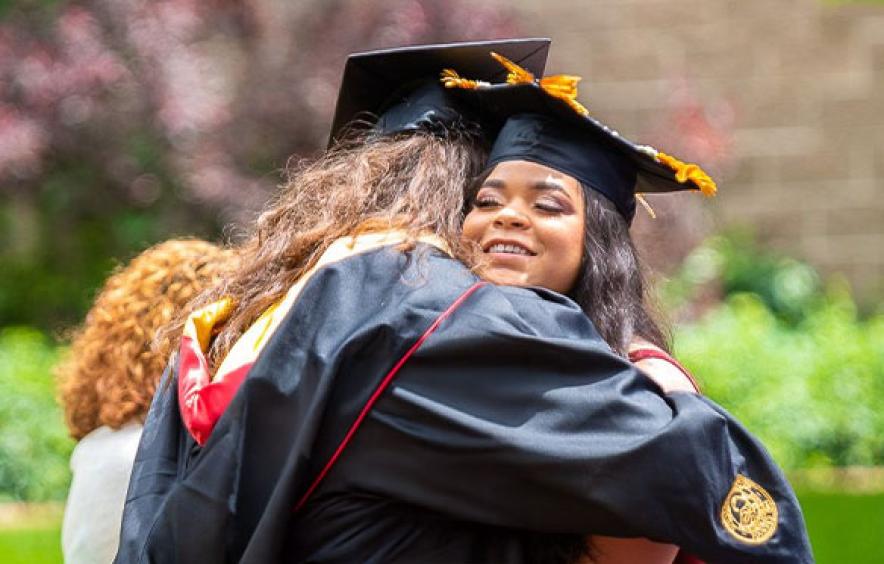 Two MSW gradautes hugging