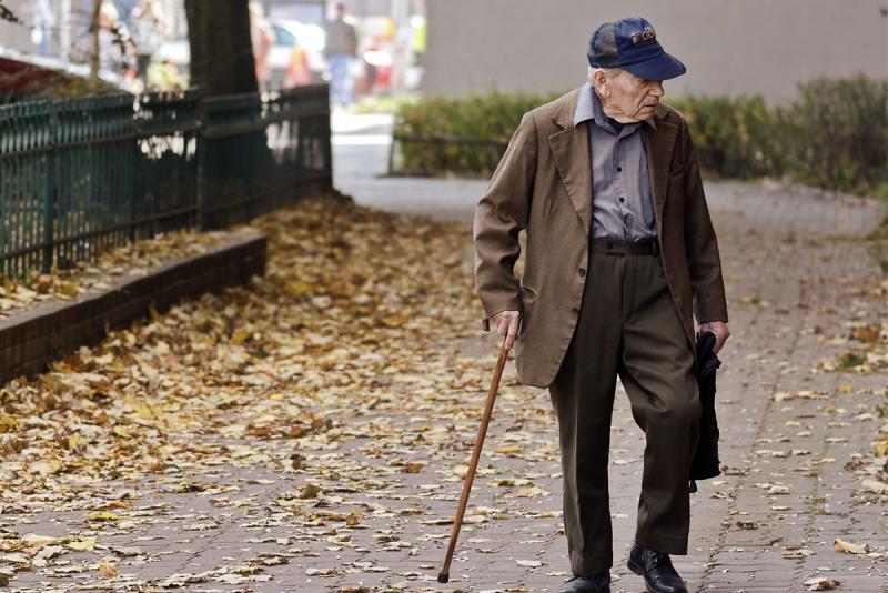 Elderly man walking on pavement