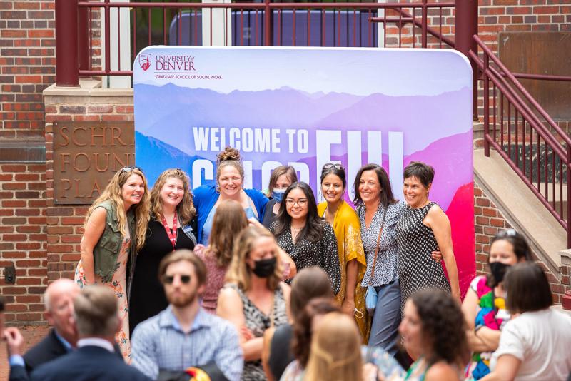 Group of people at an event posing for a photo in front of a backdrop reading Welcome to Wonderful Colorado