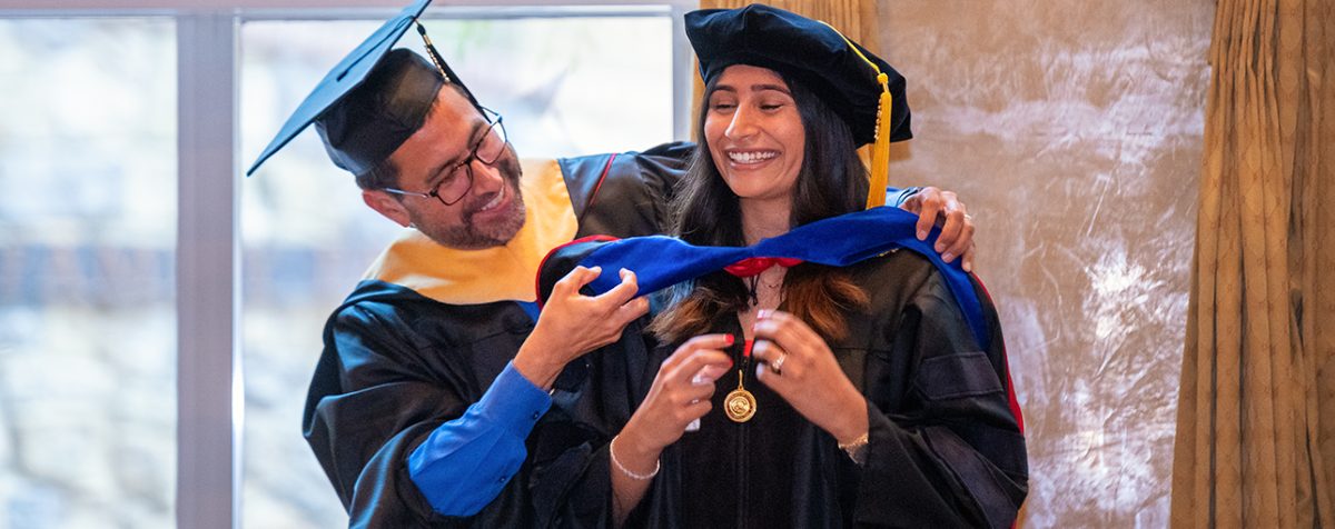 two people at hooding ceremony
