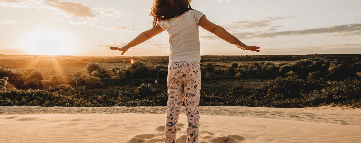 Child looking at the sky with arms stretched out