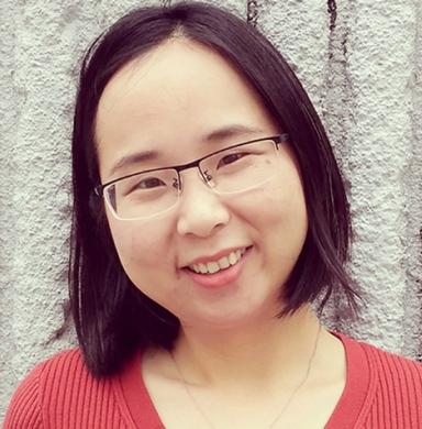 Woman with short brown hair and glasses smiles for the camera