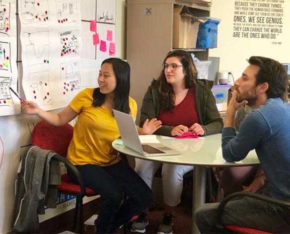 Human-centered design student Mae Thompson, BA ’18, shares her work with design consultants.