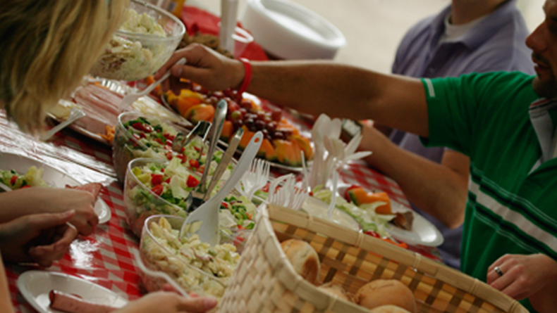family around picnic table with food